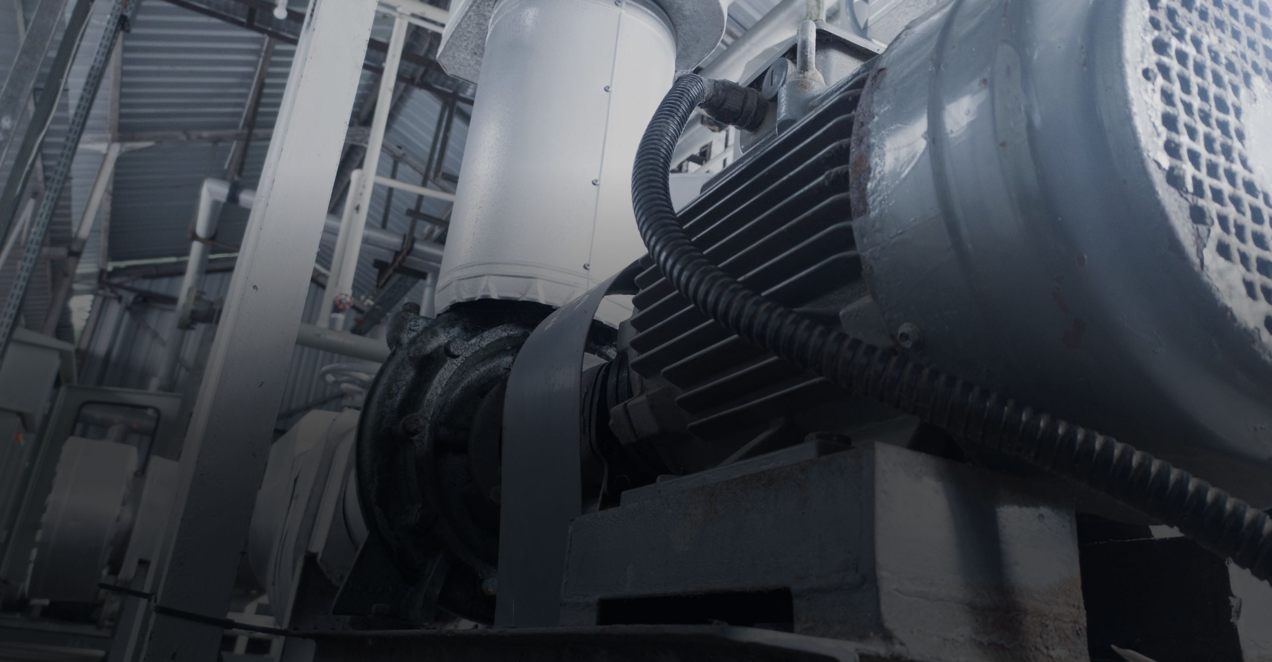 Industrieller Elektromotor mit angeschlossener Kreiselpumpe in einer Fabrikhalle